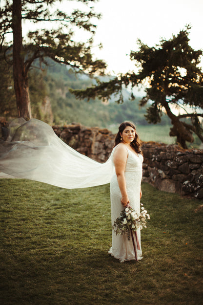 soft feminine bride in lace sheath with dyed blue cape