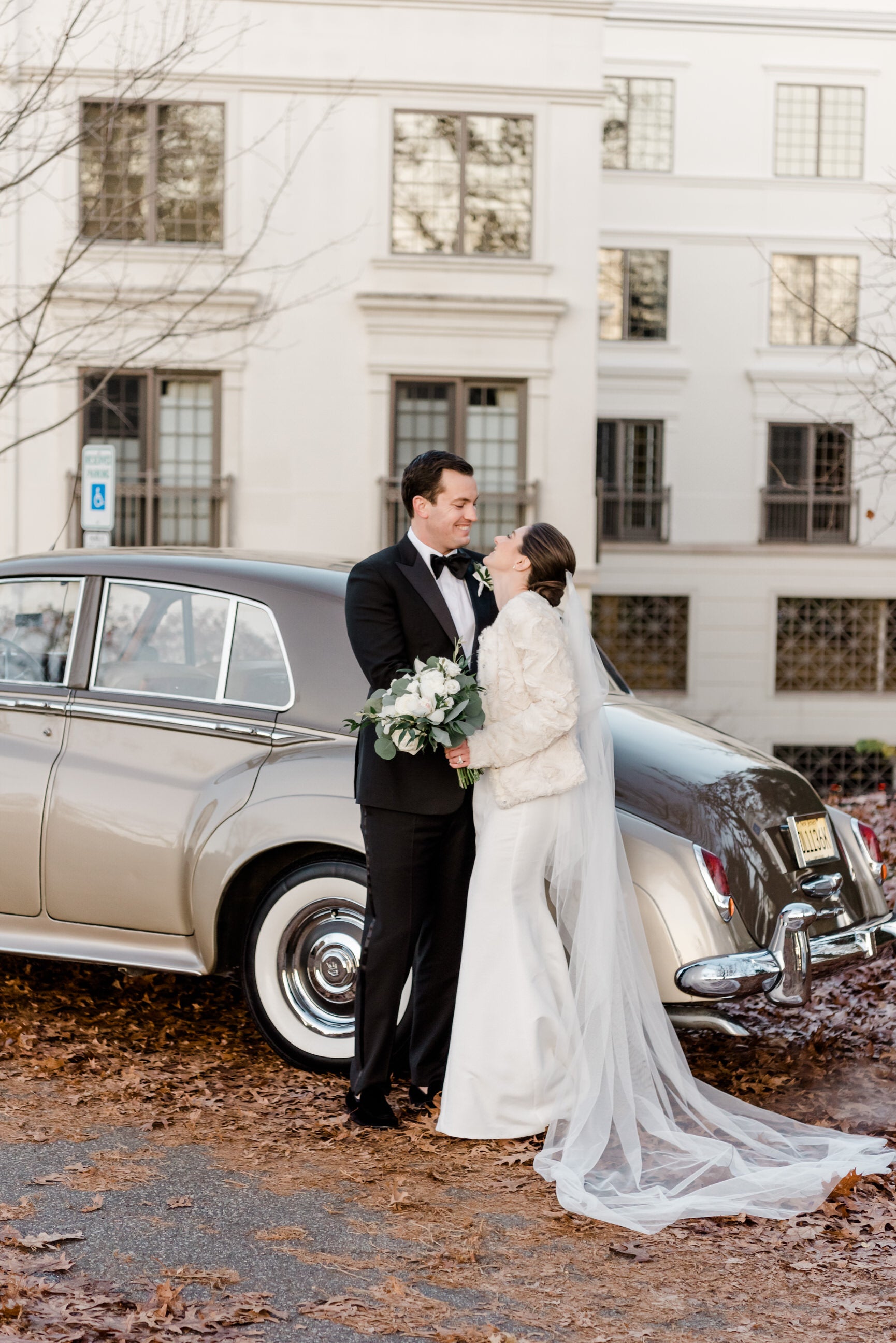 ivory English net bridal veil posing in front of getaway car