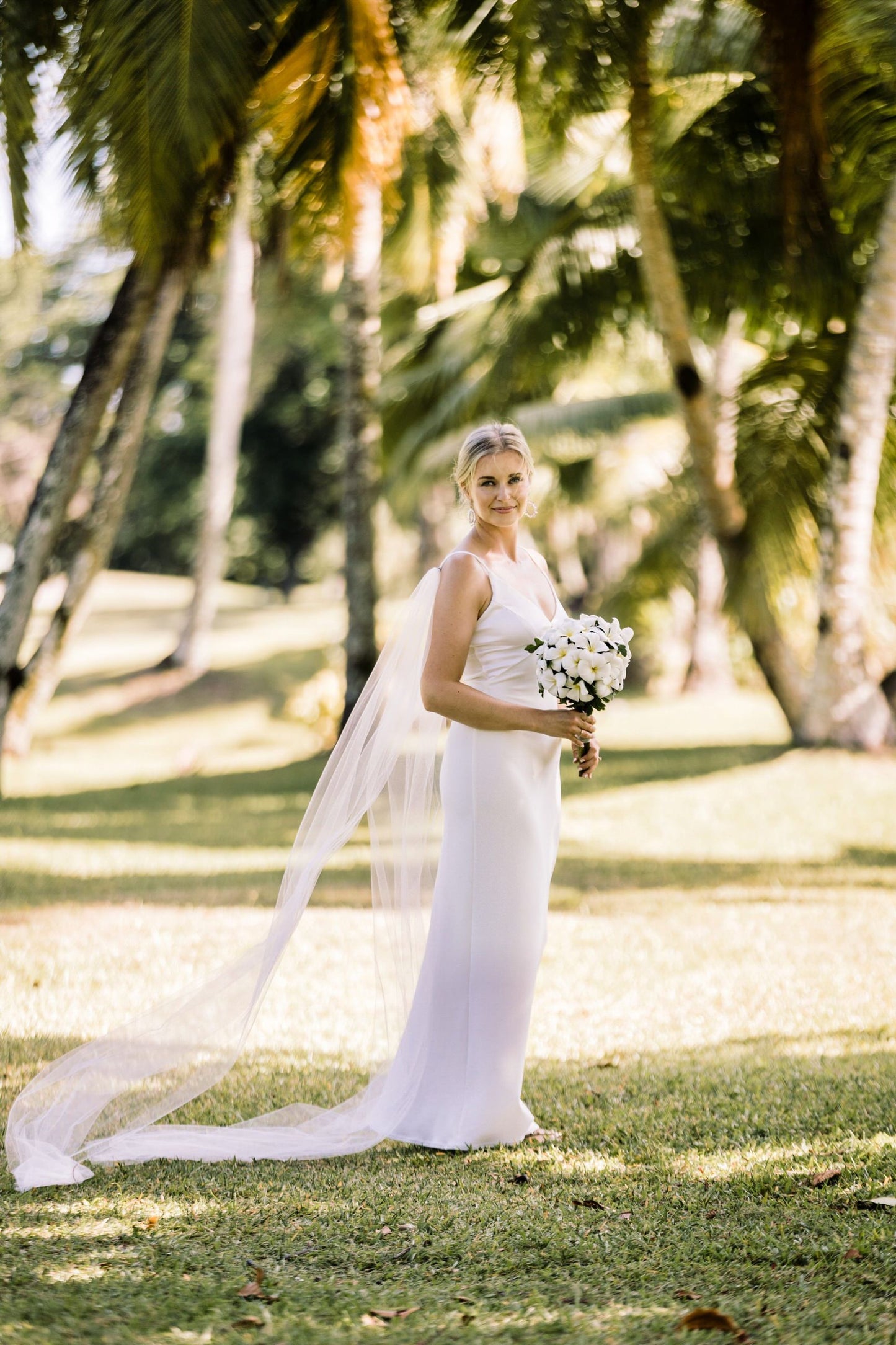 simple minimalist bride with silk gown and tulle bridal cape wings