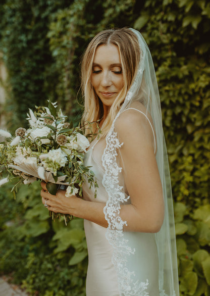 romantic lace edged mantilla fingertip length wedding veil with silk sheath gown