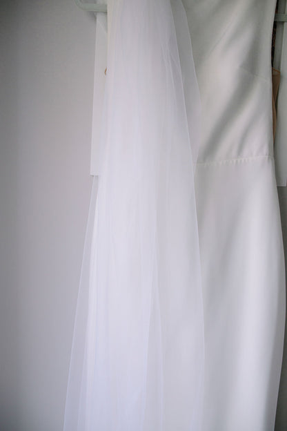 extra soft sheer silk bridal veil in off white against diamond white crepe wedding dress