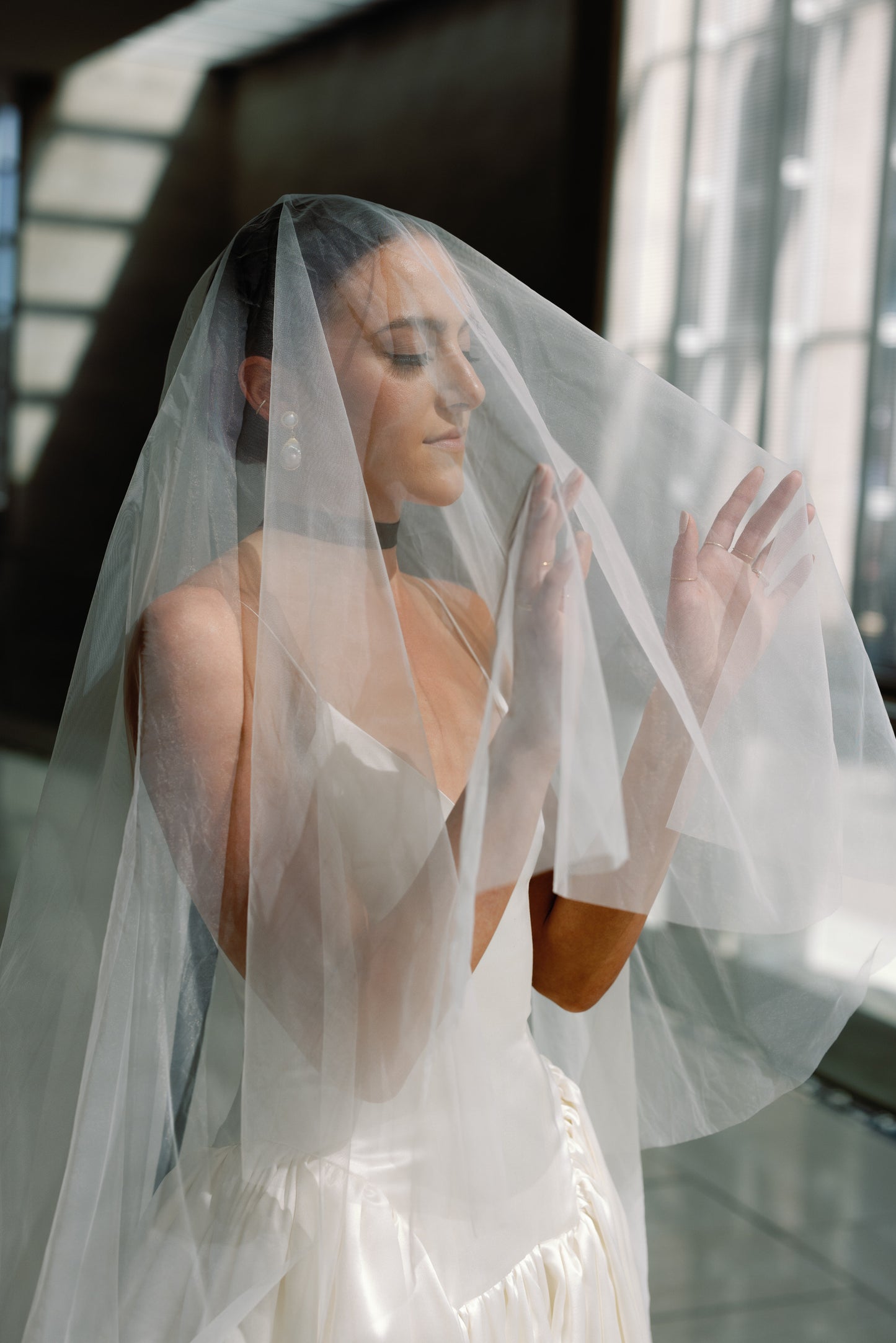 fine art sophisticated drop wedding veil with blusher over face on bride wearing black chocker necklace