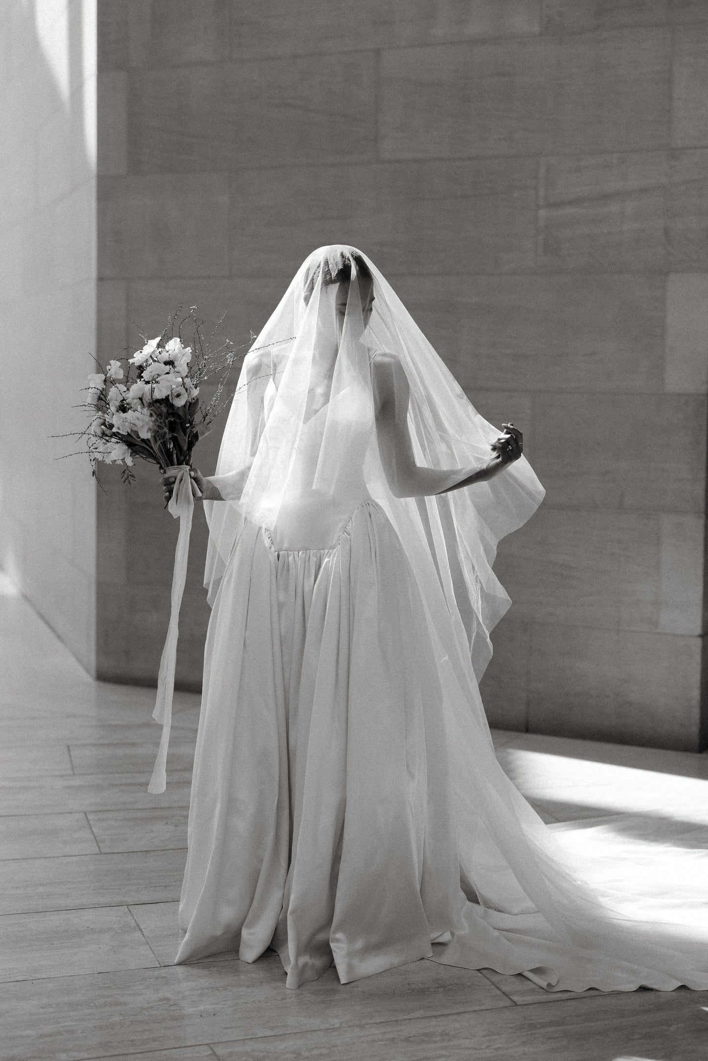 elegant bride wearing a two layer cascade wedding veil from English net fabric and holding bouquet
