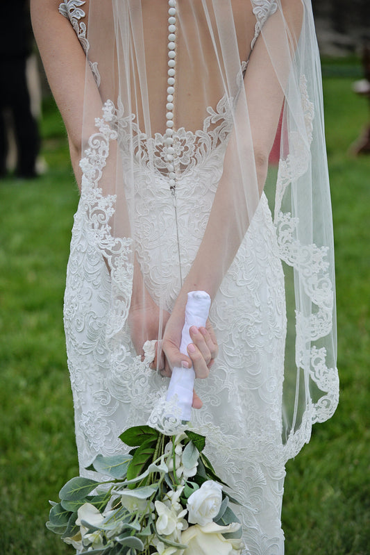 ivory lace fingertip length wedding veil with flower bouquet