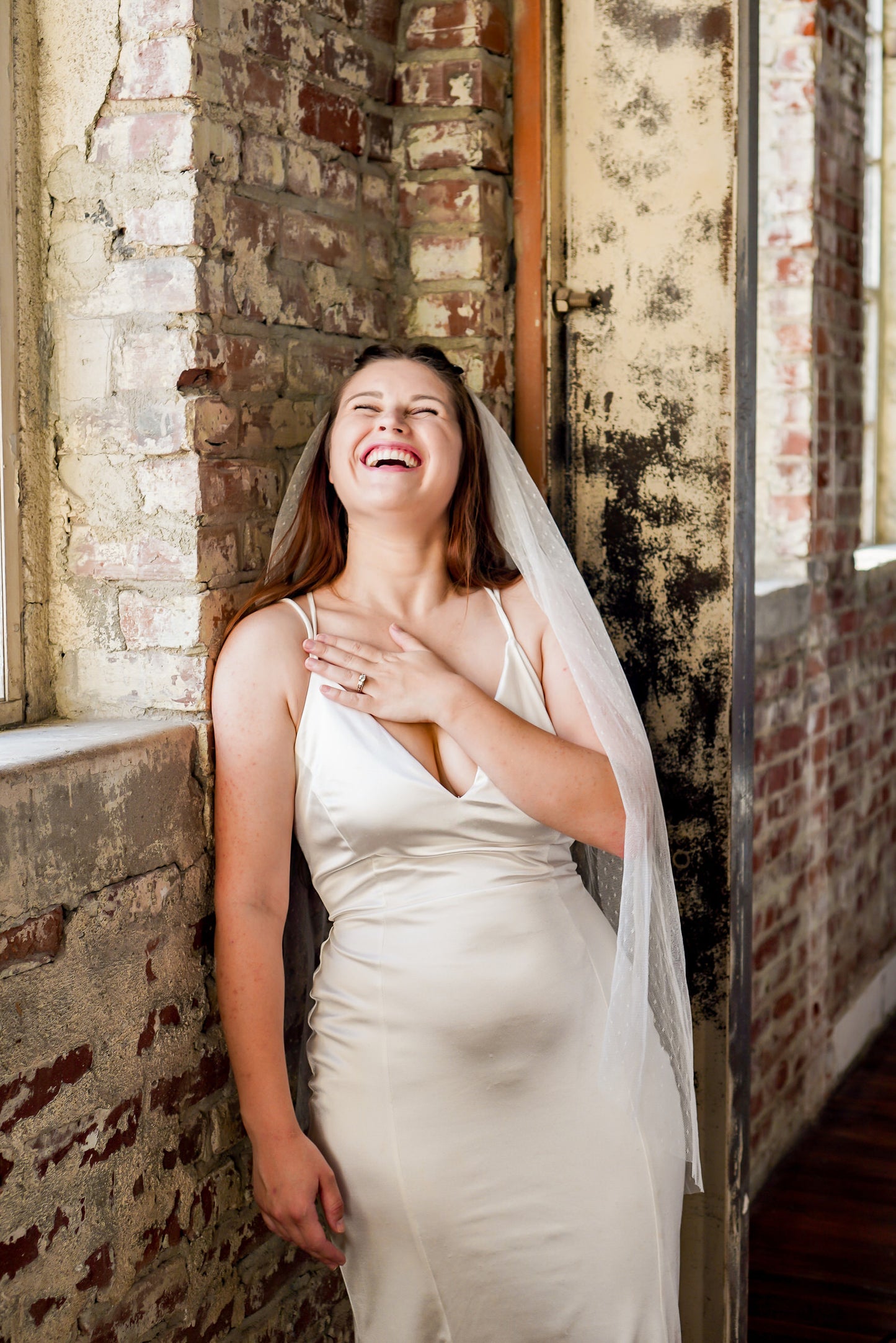 modern bride in ivory bridal veil with polka dots in a romantic industrial red brick venue
