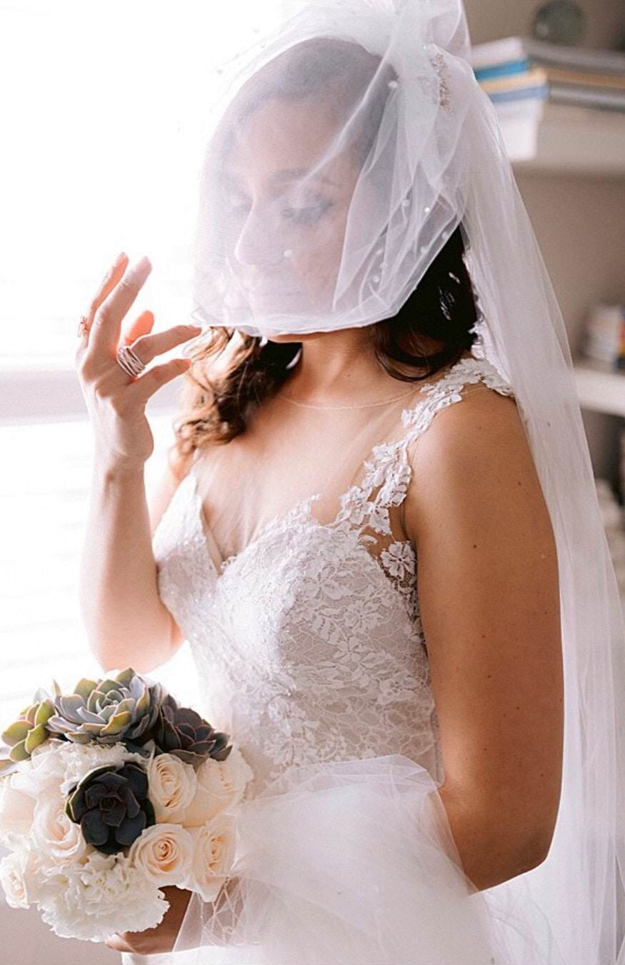 https://www.oneblushingbride.net/cdn/shop/products/modernbrideinrhinestoneblusherandlongroyallengthveil.jpg?v=1682978348&width=1445