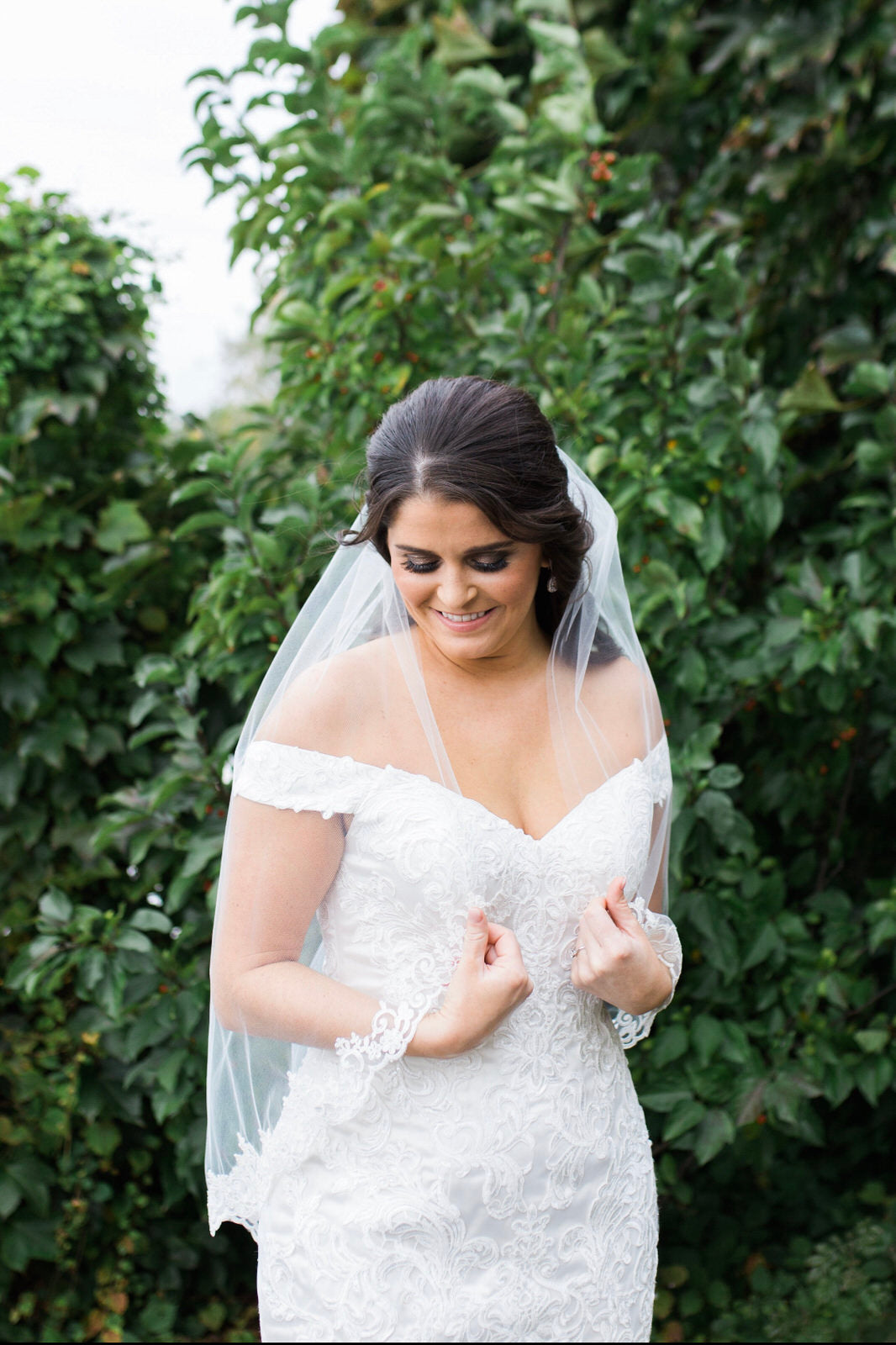 bride in waist length veil with lace in half down hairstyle 