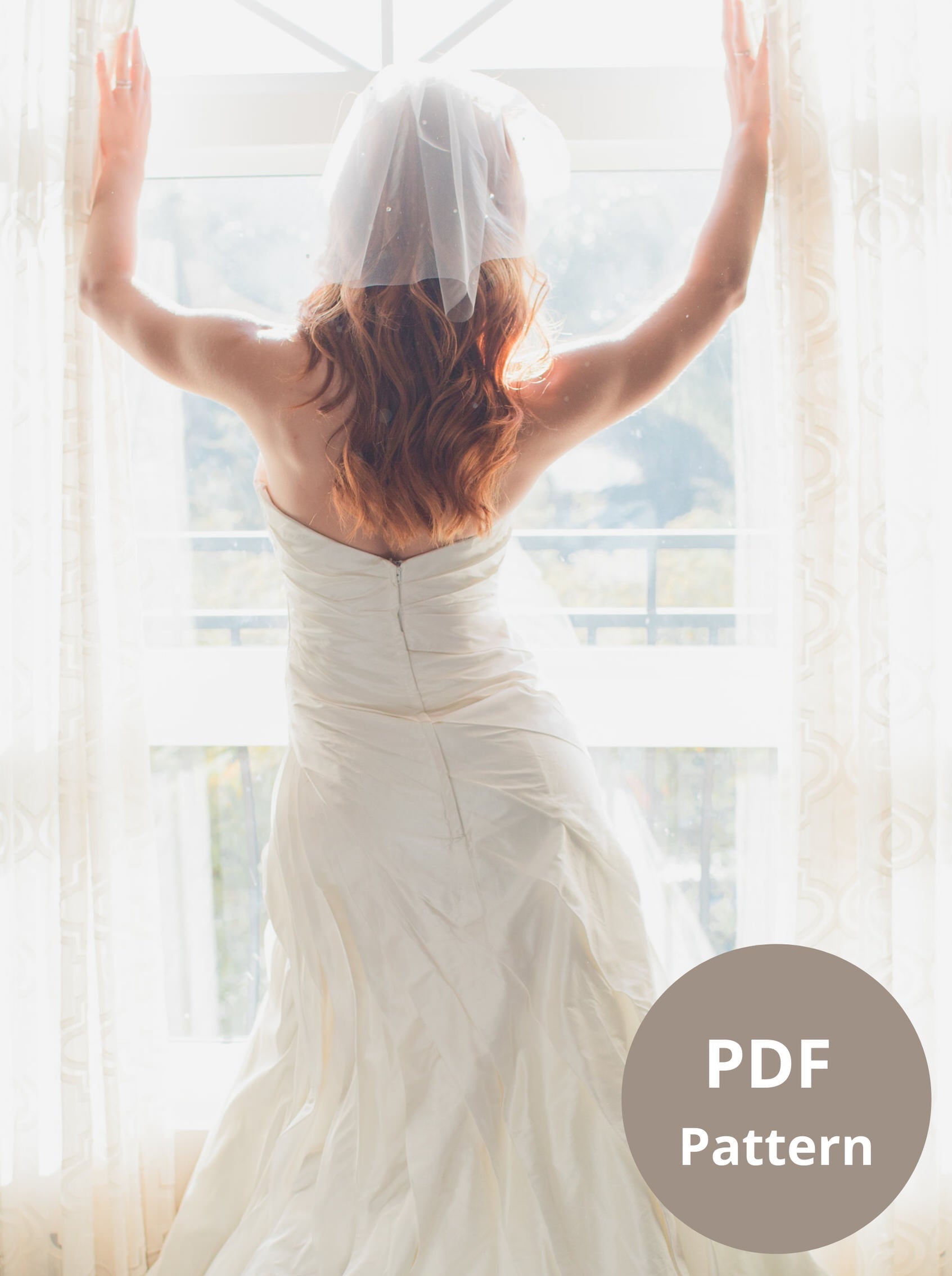 bride looking out window in short birdcage veil and strapless gown