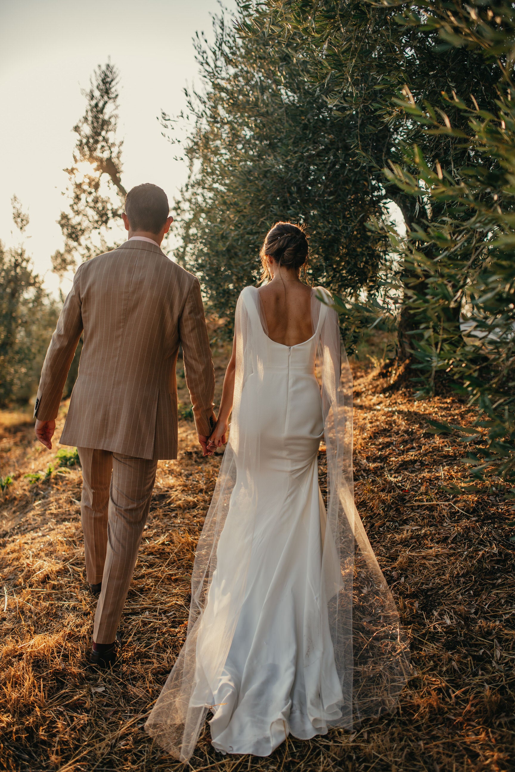 bride and groom walking with modern shoulder cape veil on shoulders