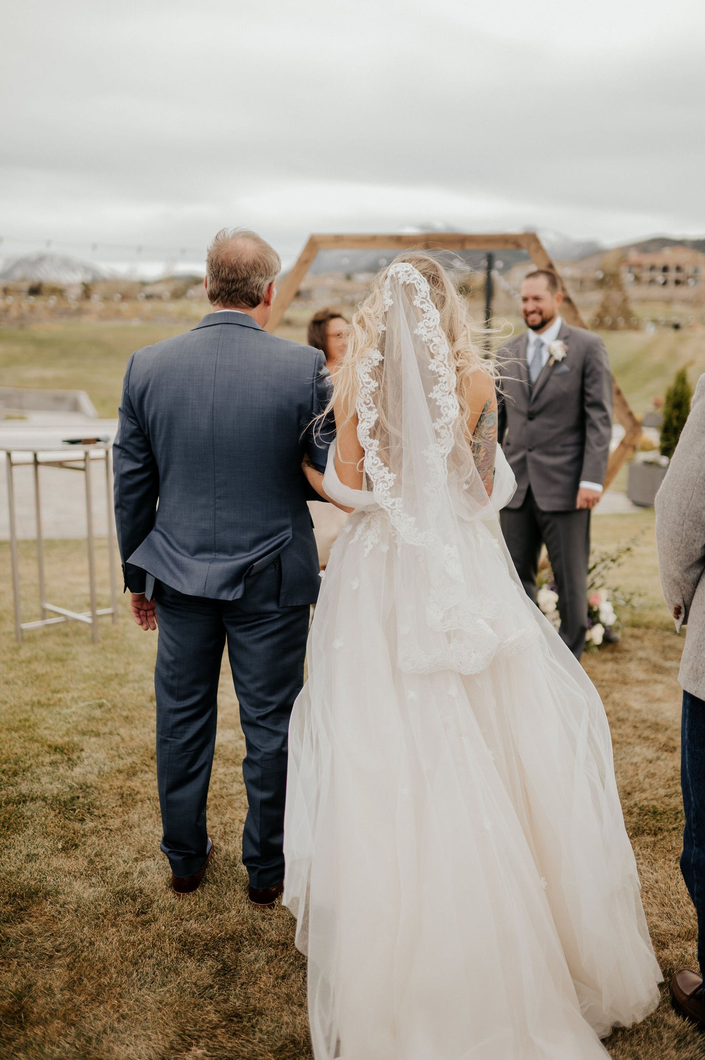 fingertip length 40 inch lace wedding veil as bride holds dad's arm for outdoor rustic ceremony
