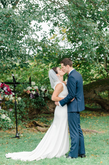 whimsical elegant wedding with bride in birdcage veil and groom kissing