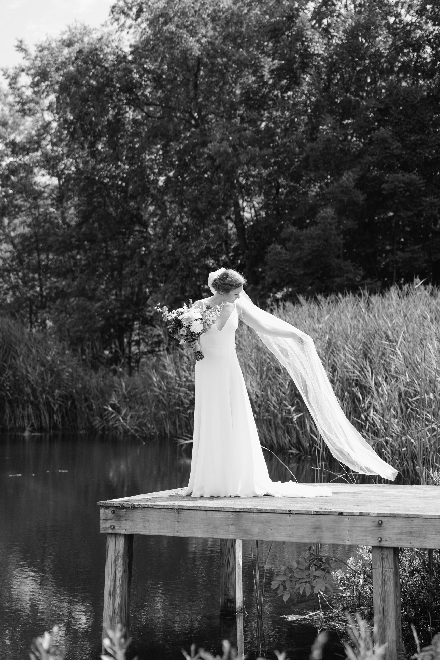 long bridal veil with raw edge for outdoor natural wedding on dock pier
