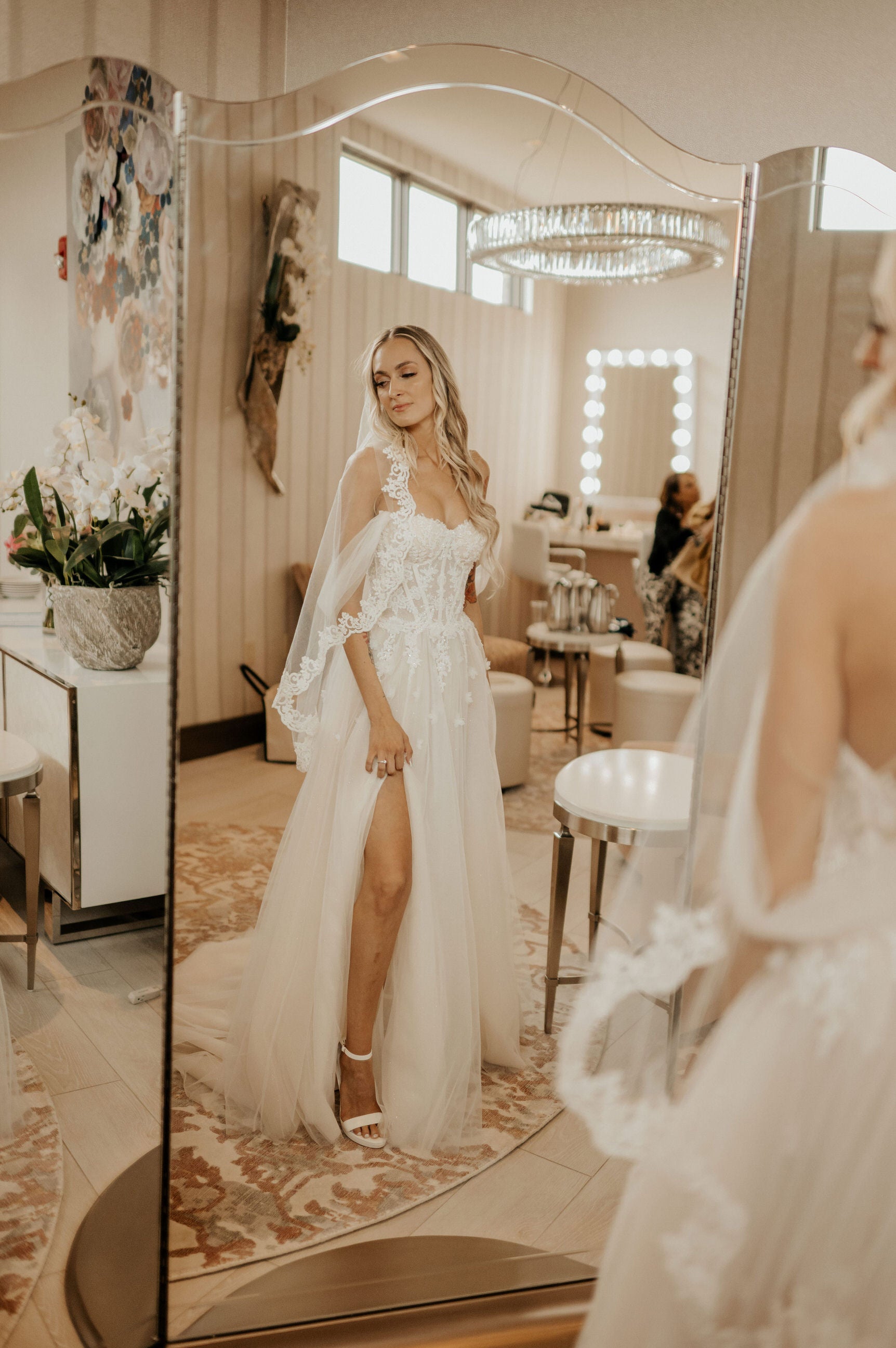 circle fingertip length bridal veil on bride with slit sexy wedding dress and looking in mirror