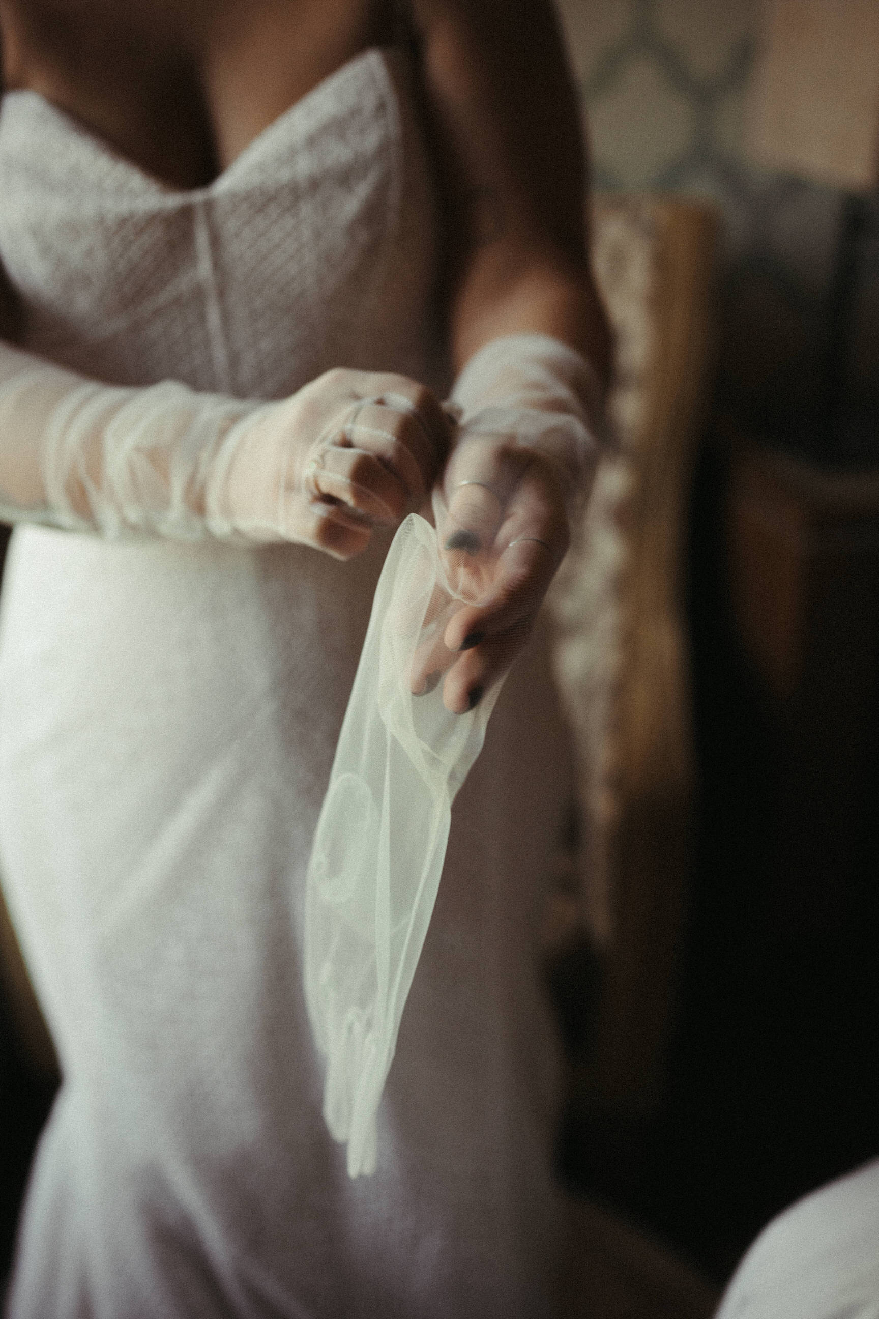 putting on wedding glove set with fingers made from see through tulle