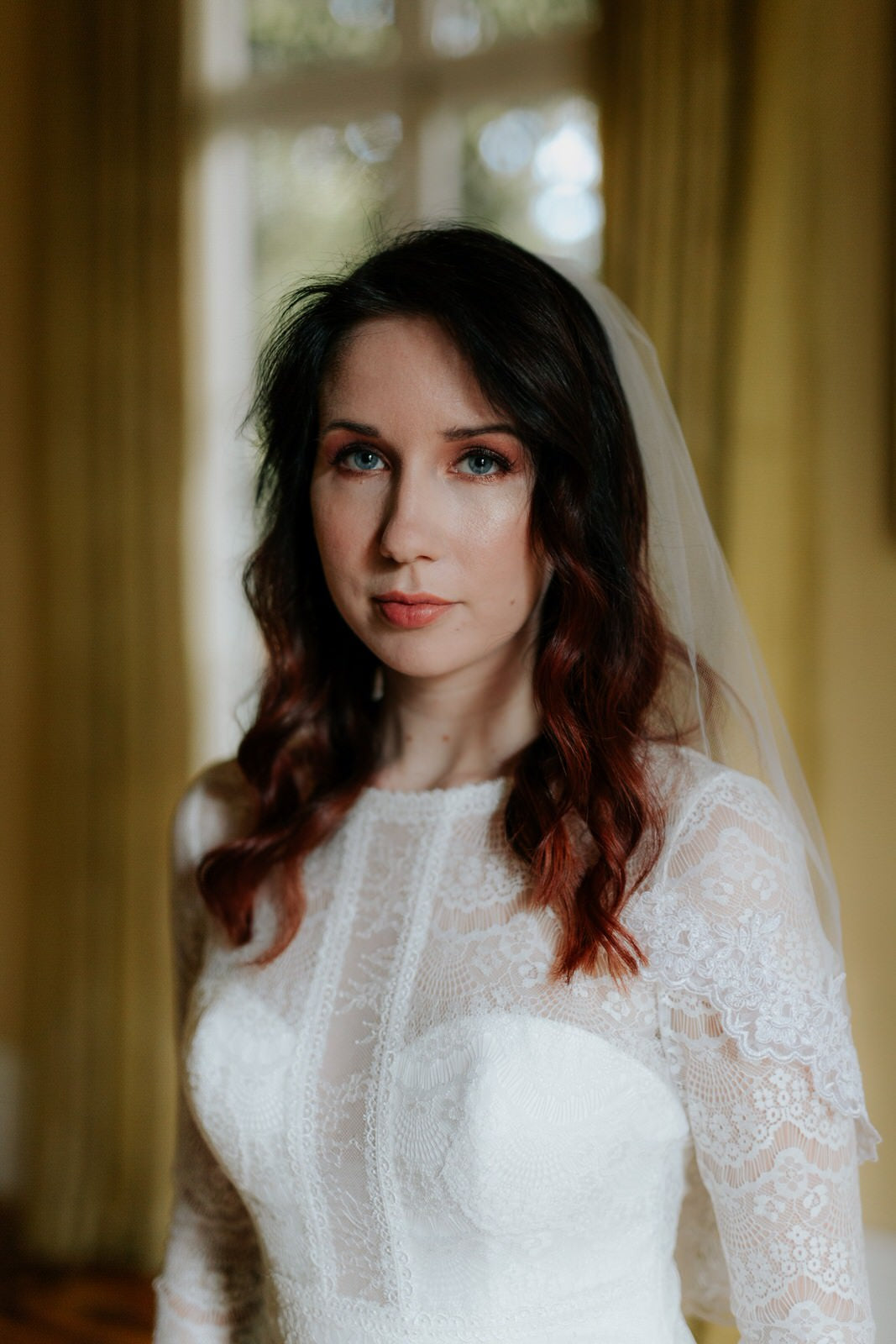 soft bohemian bride in lace dress and short trimmed wedding veil