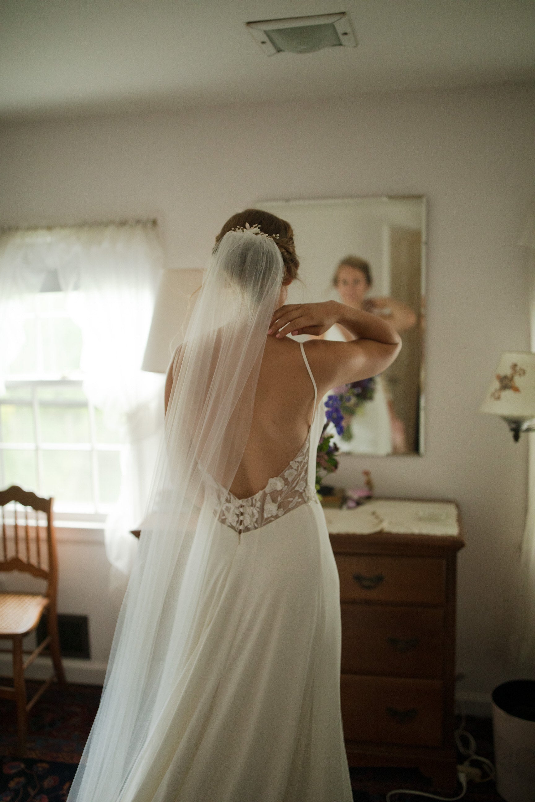 bride getting ready with thin ivory wedding veil 