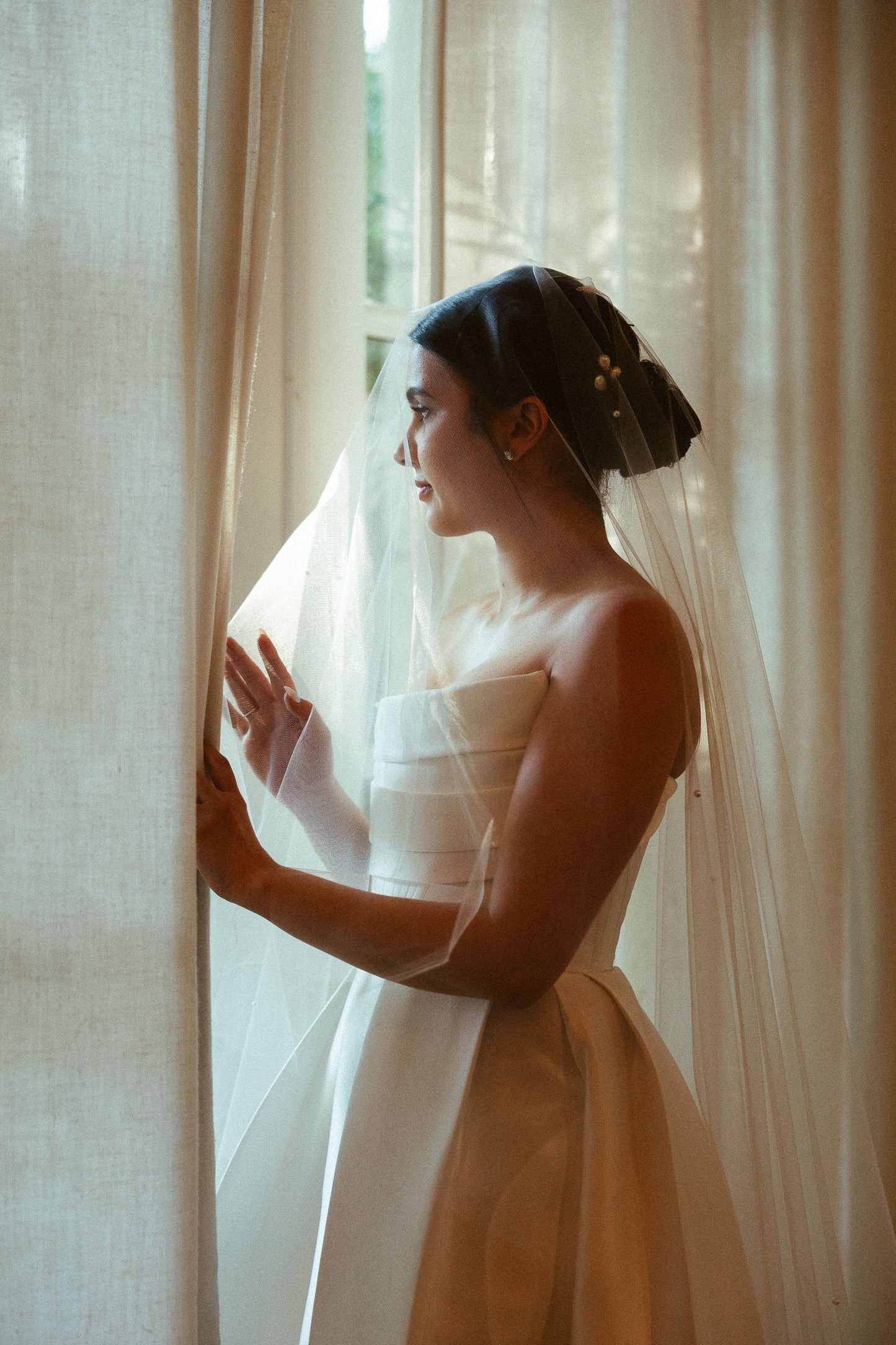 elegant low updo chignon with drop beaded wedding veil with blusher over face