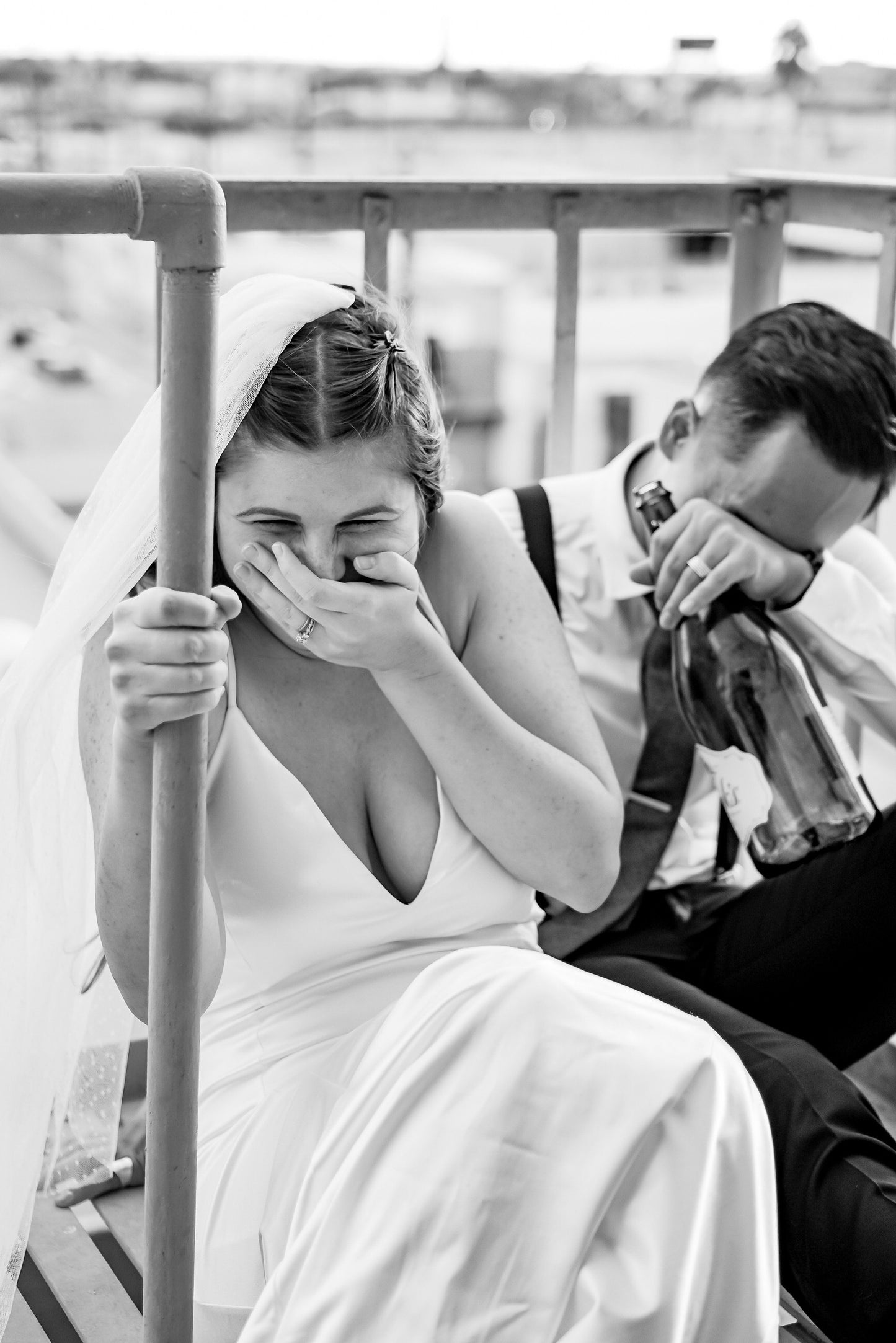 swiss dot wedding veil on bride as she laughs with groom at industrial chic venue