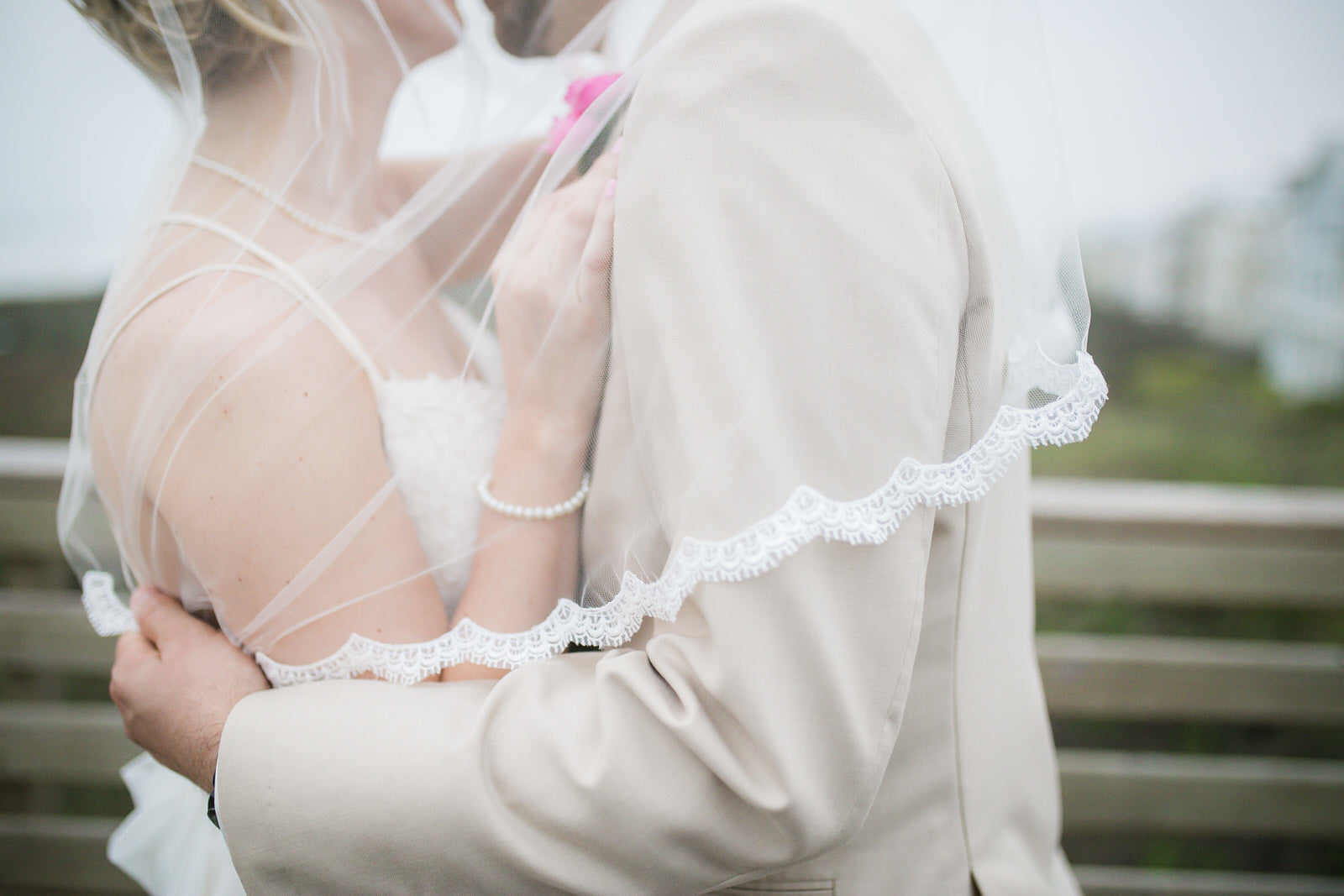 thin scallop eyelash wedding veil over bride and groom 