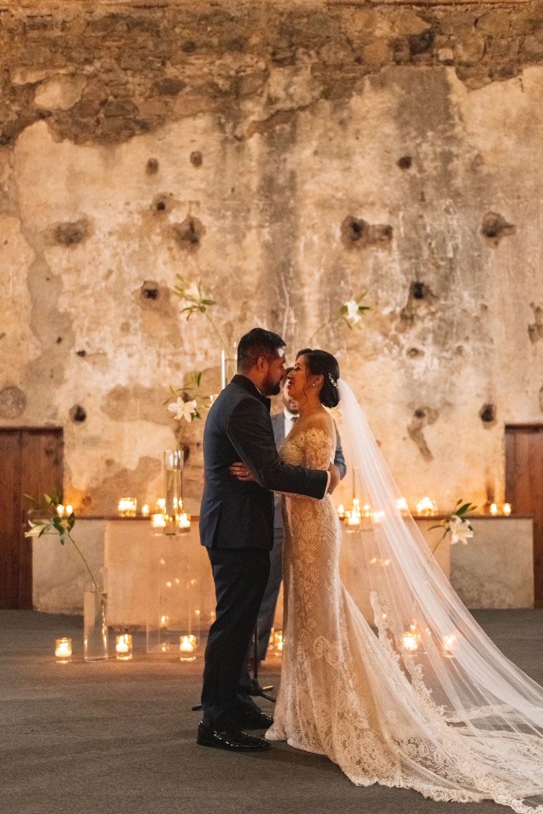 romantic spanish ruins wedding with off shoulder lace gown and french lace trimmed long wedding veil with candles 