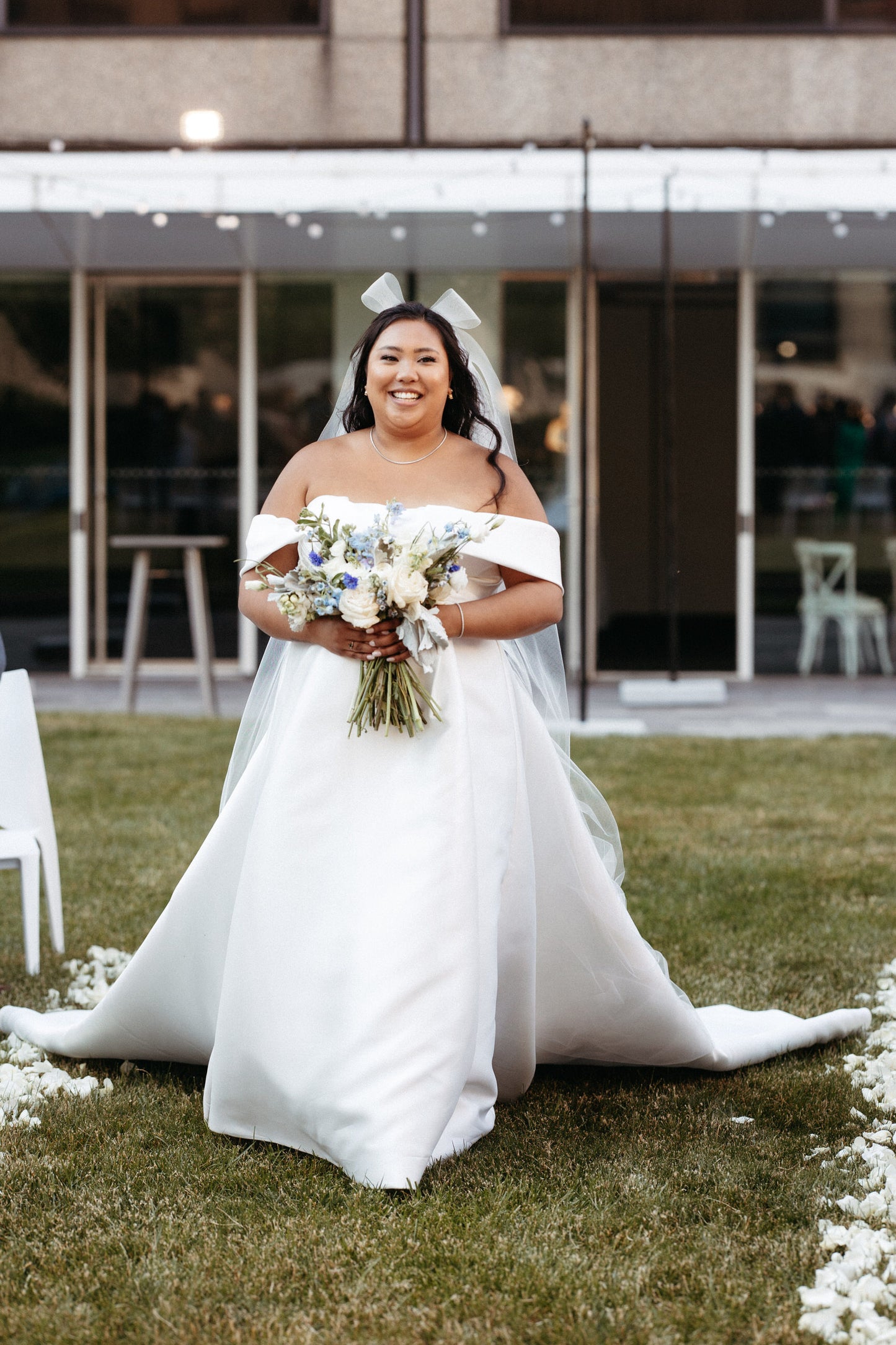 smiling bride in white bridal hair bow accessory and classic satin ballgown